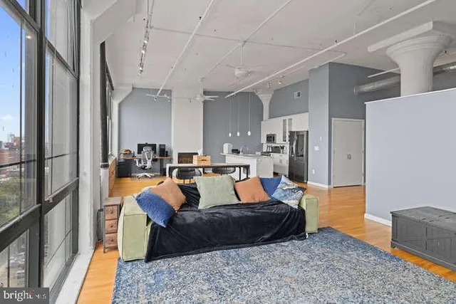 a living room with stainless steel appliances granite countertop furniture rug and wooden floor