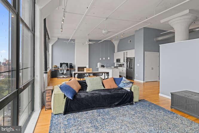 314 North 12th Street, Unit 1004 Philadelphia, PA 19107 - Photo 8 of 16 a living room with stainless steel appliances granite countertop furniture rug and wooden floor