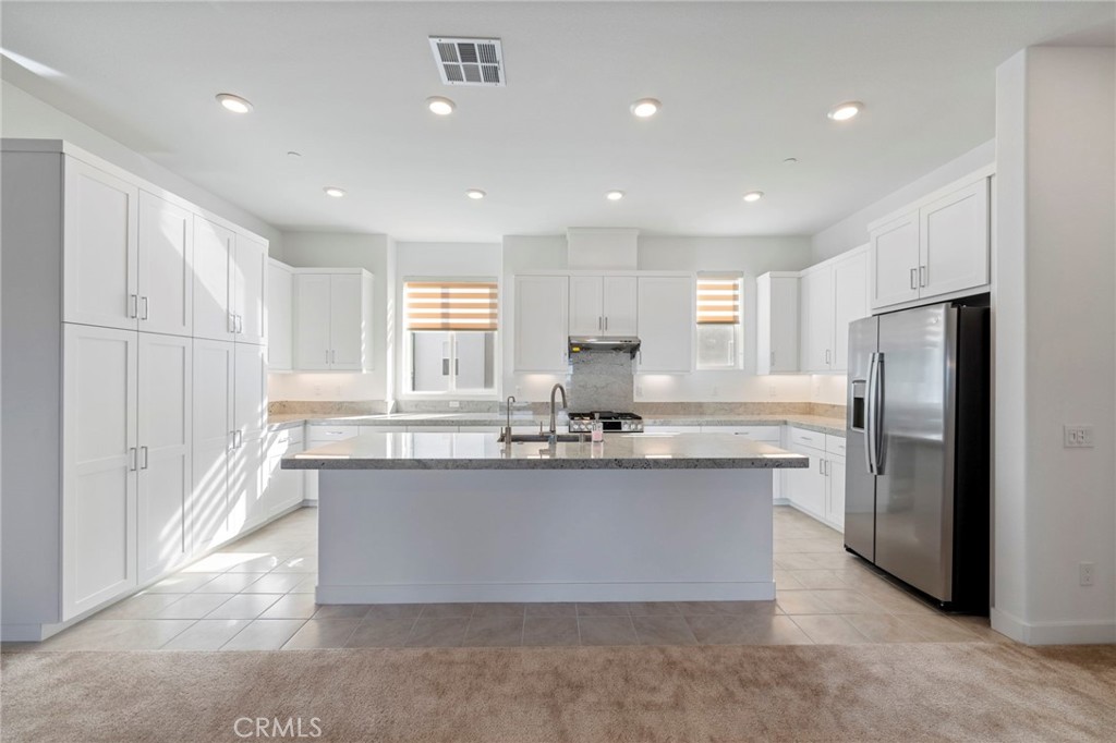 398 Merit Irvine, CA 92618 - Photo 11 of 55 a kitchen with stainless steel appliances granite countertop a sink a stove a refrigerator a center island and a window