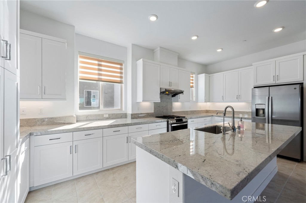 398 Merit Irvine, CA 92618 - Photo 13 of 55 a kitchen with stainless steel appliances granite countertop a sink a stove and a center island