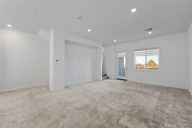a bathroom with a granite countertop toilet a sink a mirror and a window