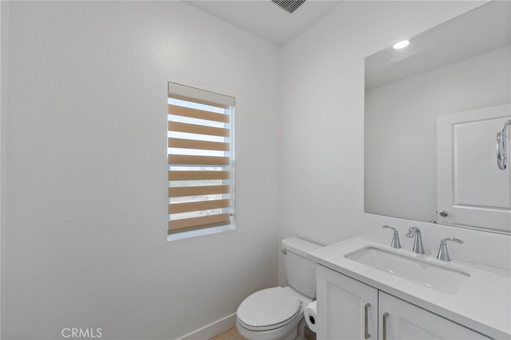 398 Merit Irvine, CA 92618 - Photo 20 of 55 a bathroom with a granite countertop toilet a sink a mirror and a window