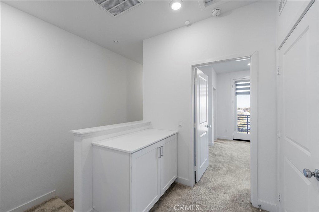 398 Merit Irvine, CA 92618 - Photo 21 of 55 a hallway with white cabinets and wooden floor