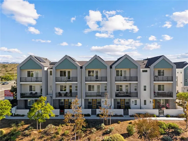 a front view of a residential apartment building with yard and retail shops