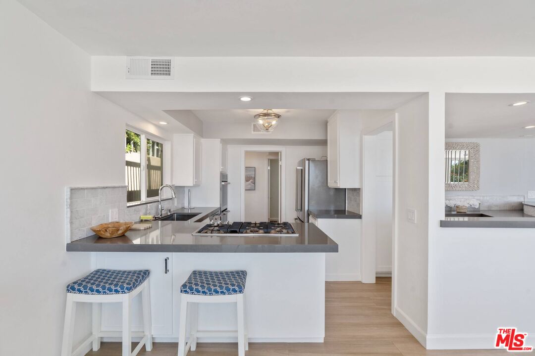 31518 Broad Beach Road Malibu, CA 90265 - Photo 14 of 27 a hallway with white cabinets and chandelier