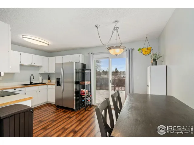 a kitchen with stainless steel appliances granite countertop a refrigerator a oven a stove and a sink with dishwasher