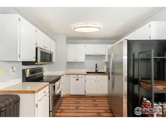 a kitchen with stainless steel appliances granite countertop a refrigerator a stove and a sink
