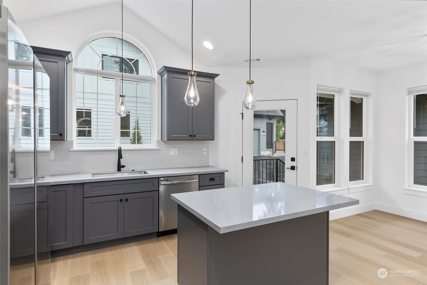 22713 1st Place West Bothell, WA 98021 - Photo 8 of 29 a kitchen with stainless steel appliances a sink a stove a refrigerator and island with wooden floor