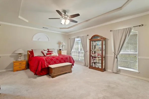a spacious bedroom with a bed and a ceiling fan