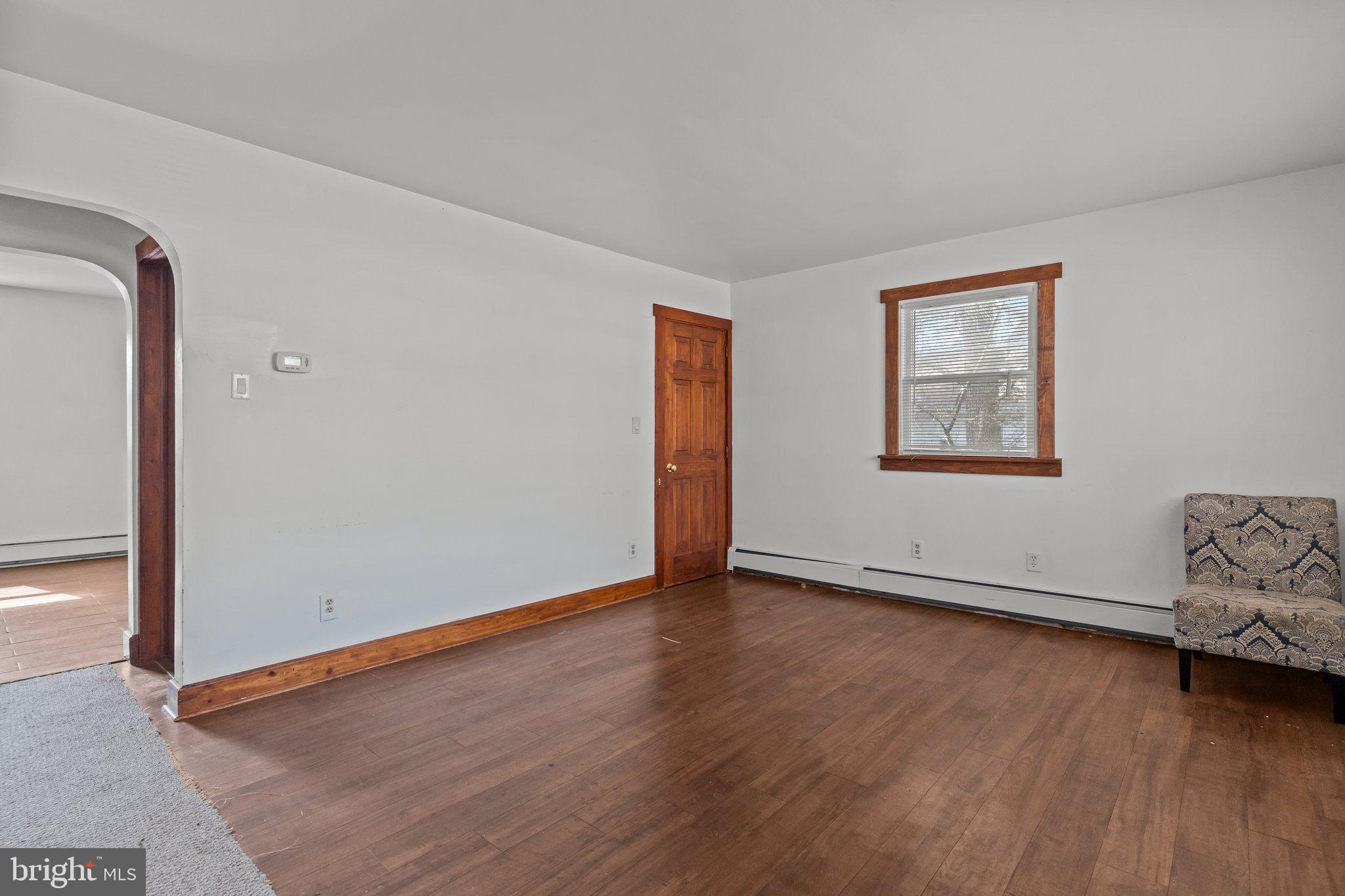 52 East 9th Avenue Pine Hill, NJ 08021 - Photo 4 of 25 an empty room with wooden floor and windows