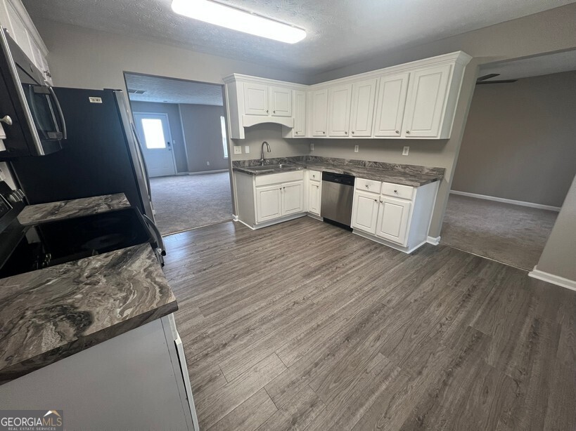 70 Princeton Way Covington, GA 30016 - Photo 11 of 32 a kitchen with stainless steel appliances granite countertop a stove a sink and a refrigerator