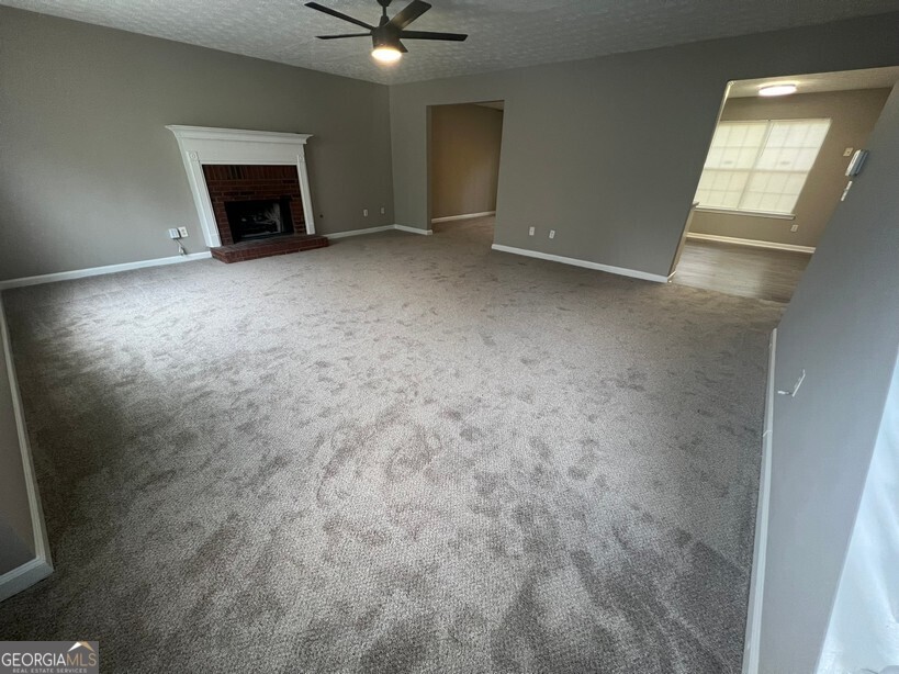 70 Princeton Way Covington, GA 30016 - Photo 2 of 32 en empty room with windows and fireplace