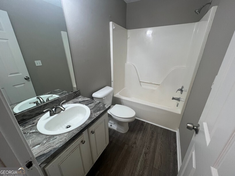 70 Princeton Way Covington, GA 30016 - Photo 25 of 32 a bathroom with a granite countertop sink toilet a mirror and shower