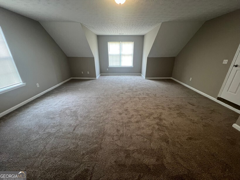 70 Princeton Way Covington, GA 30016 - Photo 28 of 32 an empty room with a fireplace and windows