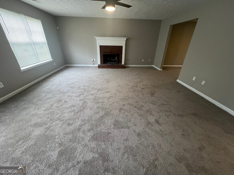 70 Princeton Way Covington, GA 30016 - Photo 3 of 32 an empty room with windows and fireplace