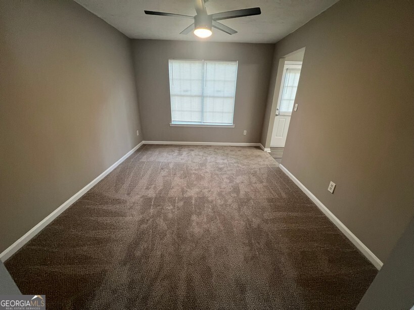 70 Princeton Way Covington, GA 30016 - Photo 7 of 32 an empty room with wooden floor and windows
