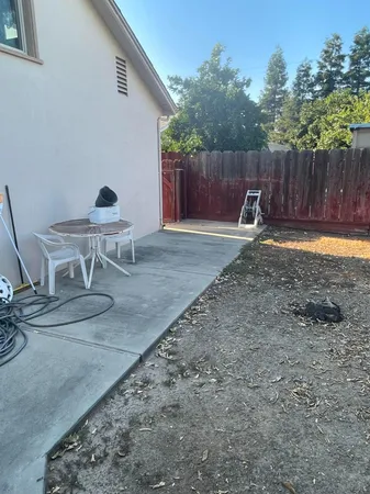 a backyard of a house with table and chairs