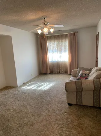 a living room with furniture and a chandelier