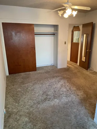 an empty room with closet and mirror