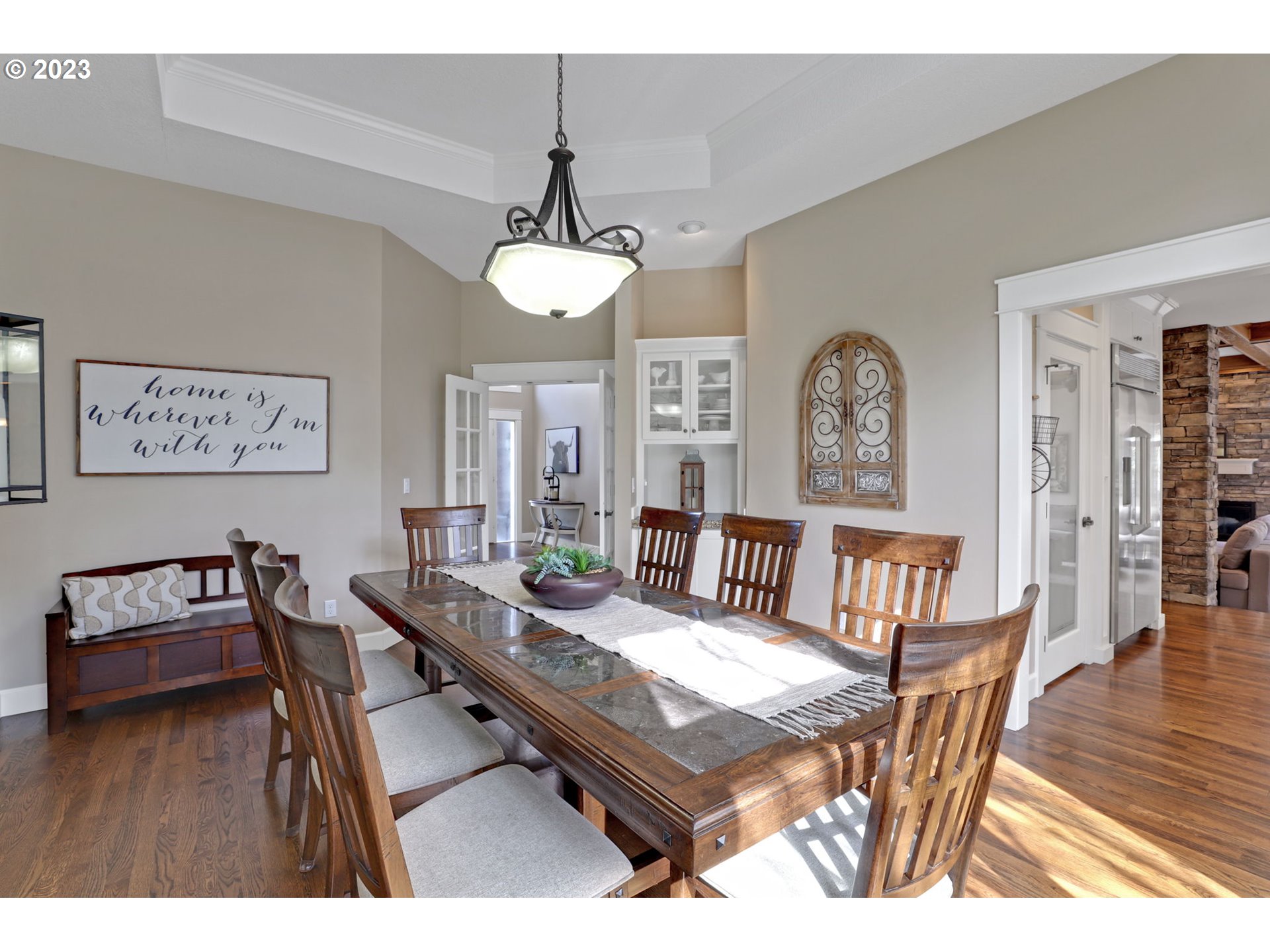 3566 Northwest Bronson Crest Loop Portland, OR 97229 - Photo 4 of 31 a dining room with wooden floor a chandelier a wooden table and chairs