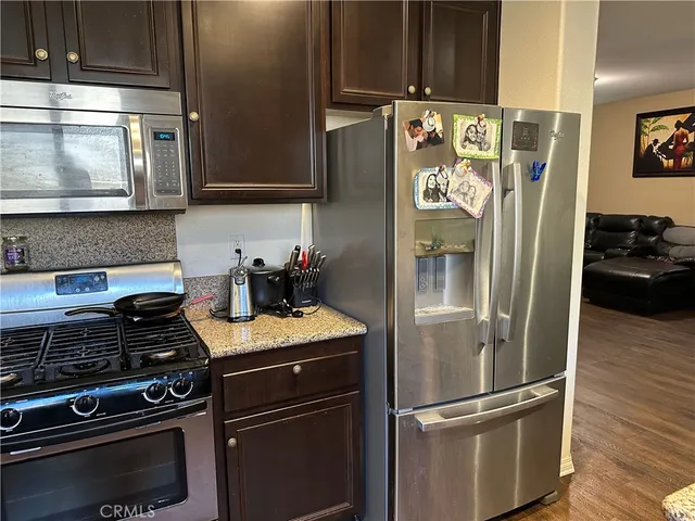 a kitchen with stainless steel appliances granite countertop a refrigerator and a stove