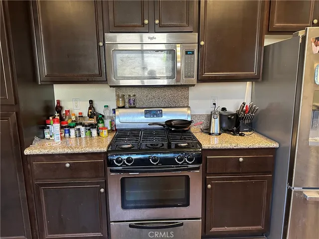 a kitchen with stainless steel appliances granite countertop a stove and a microwave