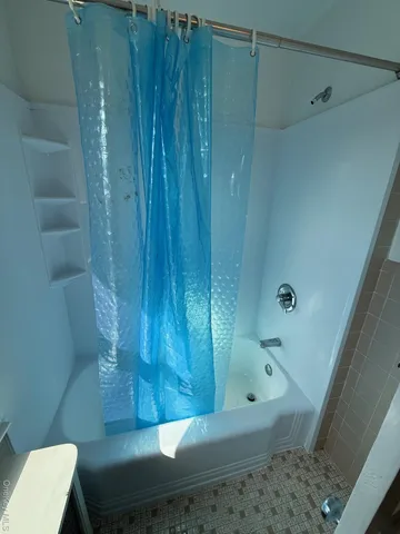 a bathroom with a bathtub and shower