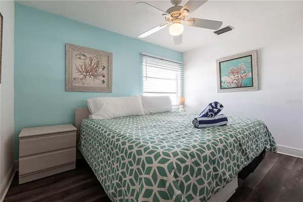 a bedroom with bed and paintings on the wall