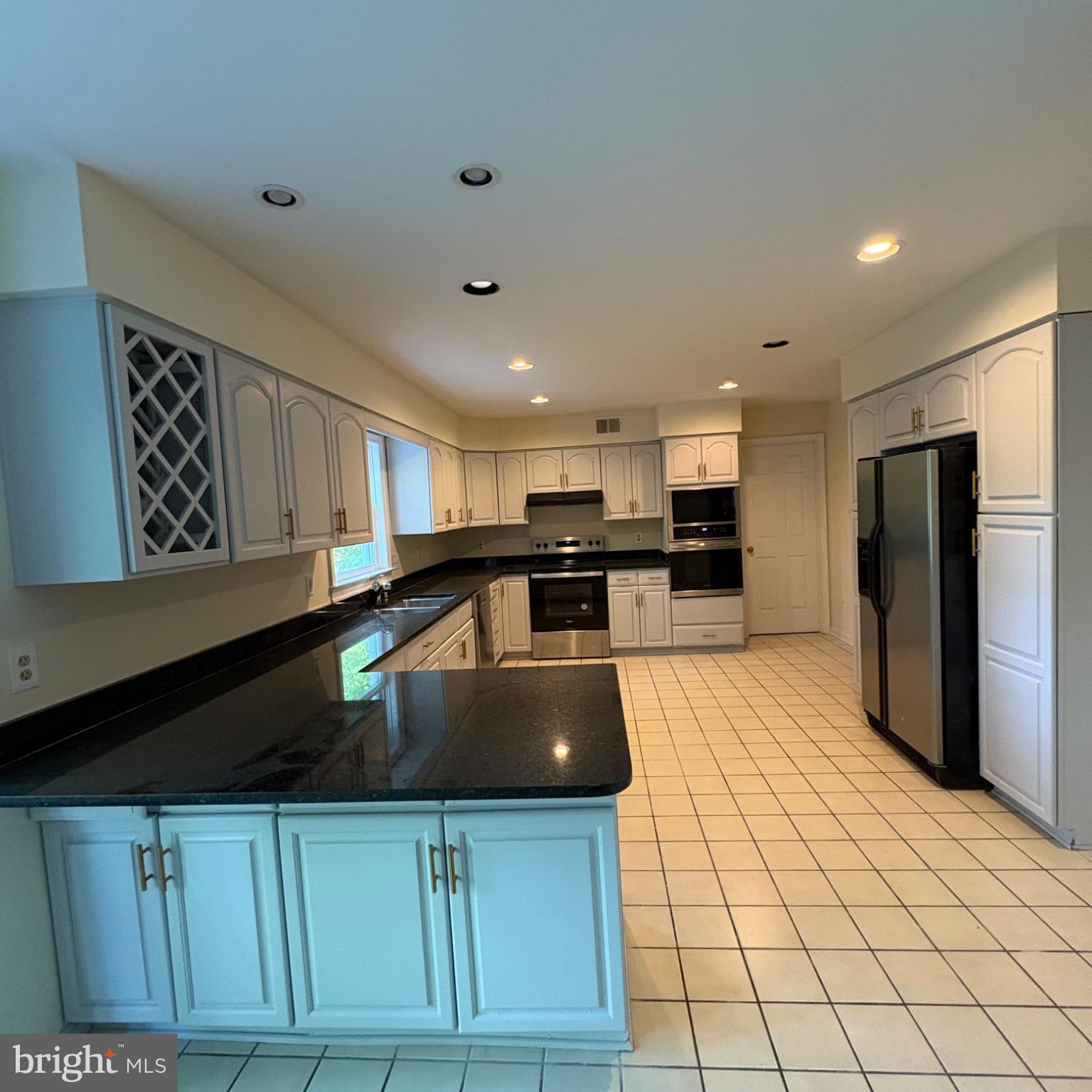 3502 Holly Road Annandale, VA 22003 - Photo 6 of 57 a kitchen with stainless steel appliances granite countertop a sink a stove and a refrigerator