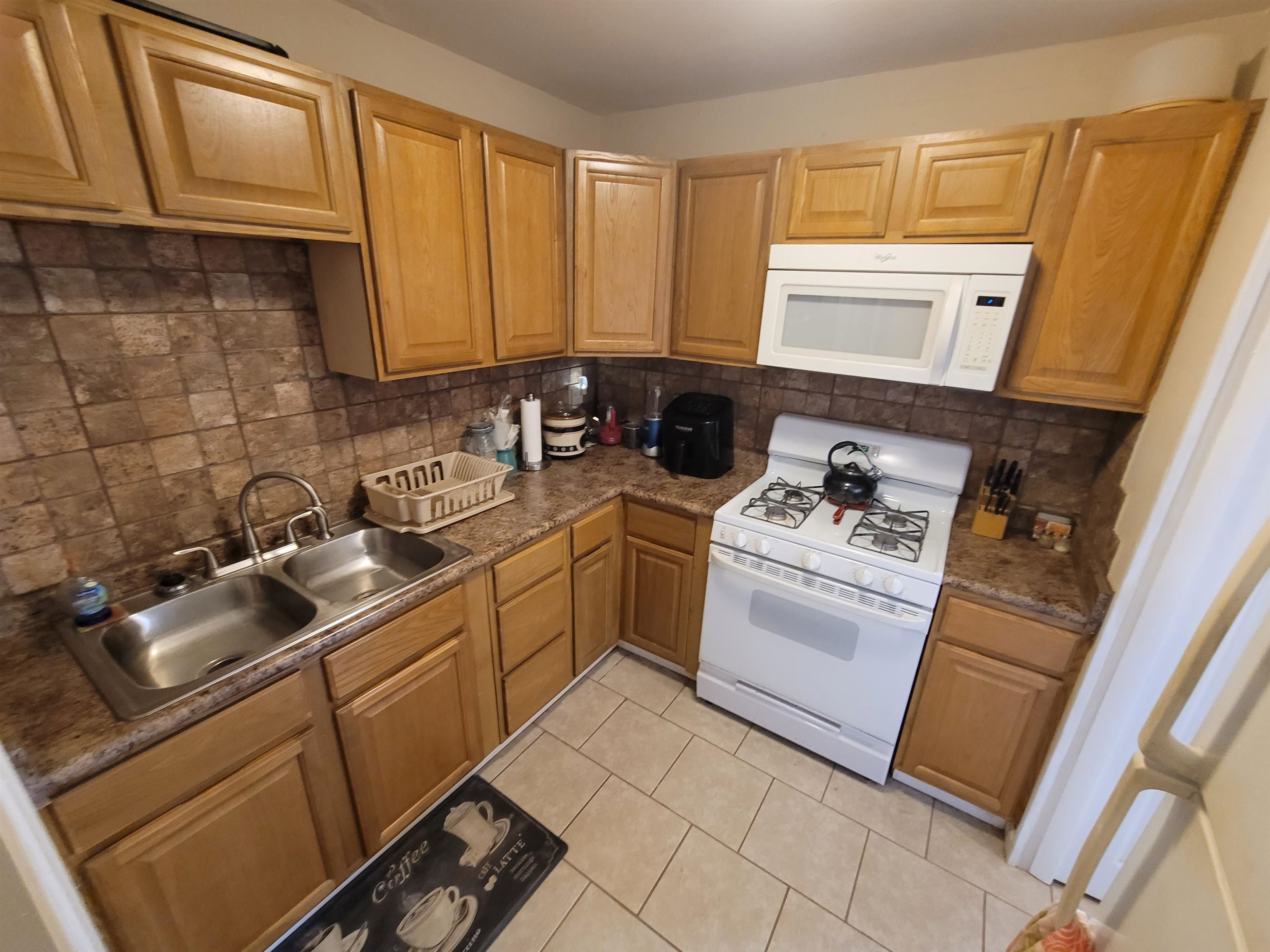 476 Jenson Road Memphis, TN 38109 - Photo 23 of 30 Kitchen featuring wood-finish cabinetry, a tiled backsplash, and stone-finish countertops