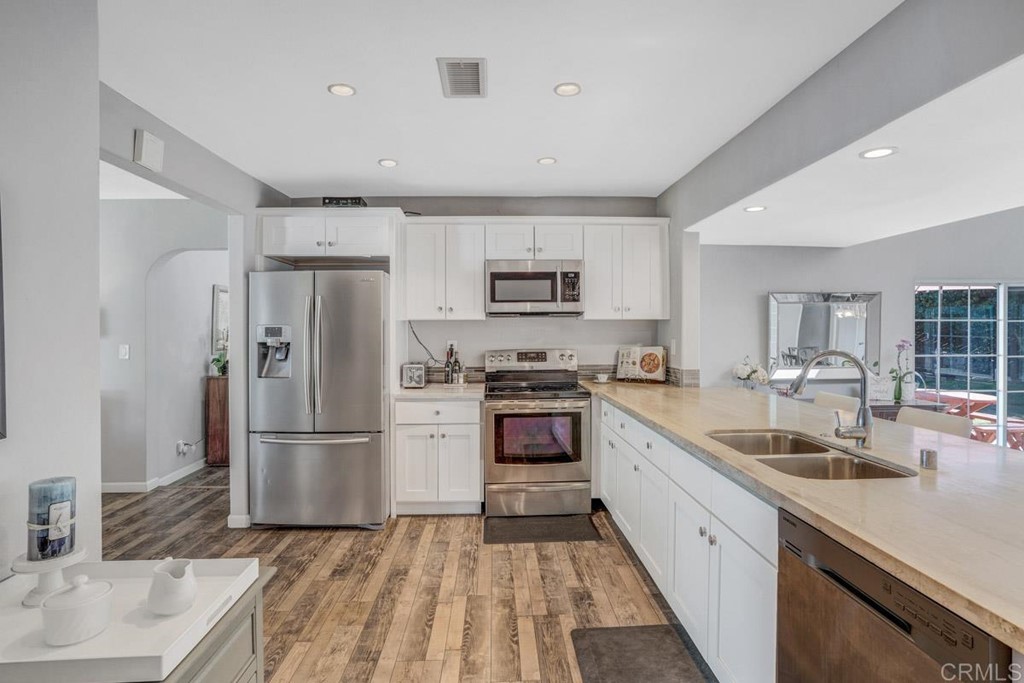 441 Bougher Road San Marcos, CA 92069 - Photo 10 of 39 a kitchen with a sink a refrigerator a microwave and cabinets