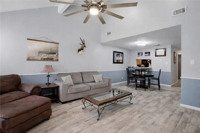 a living room with furniture and a ceiling fan