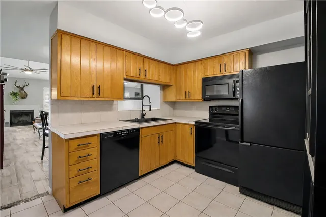 a kitchen with stainless steel appliances granite countertop a refrigerator a stove and a sink