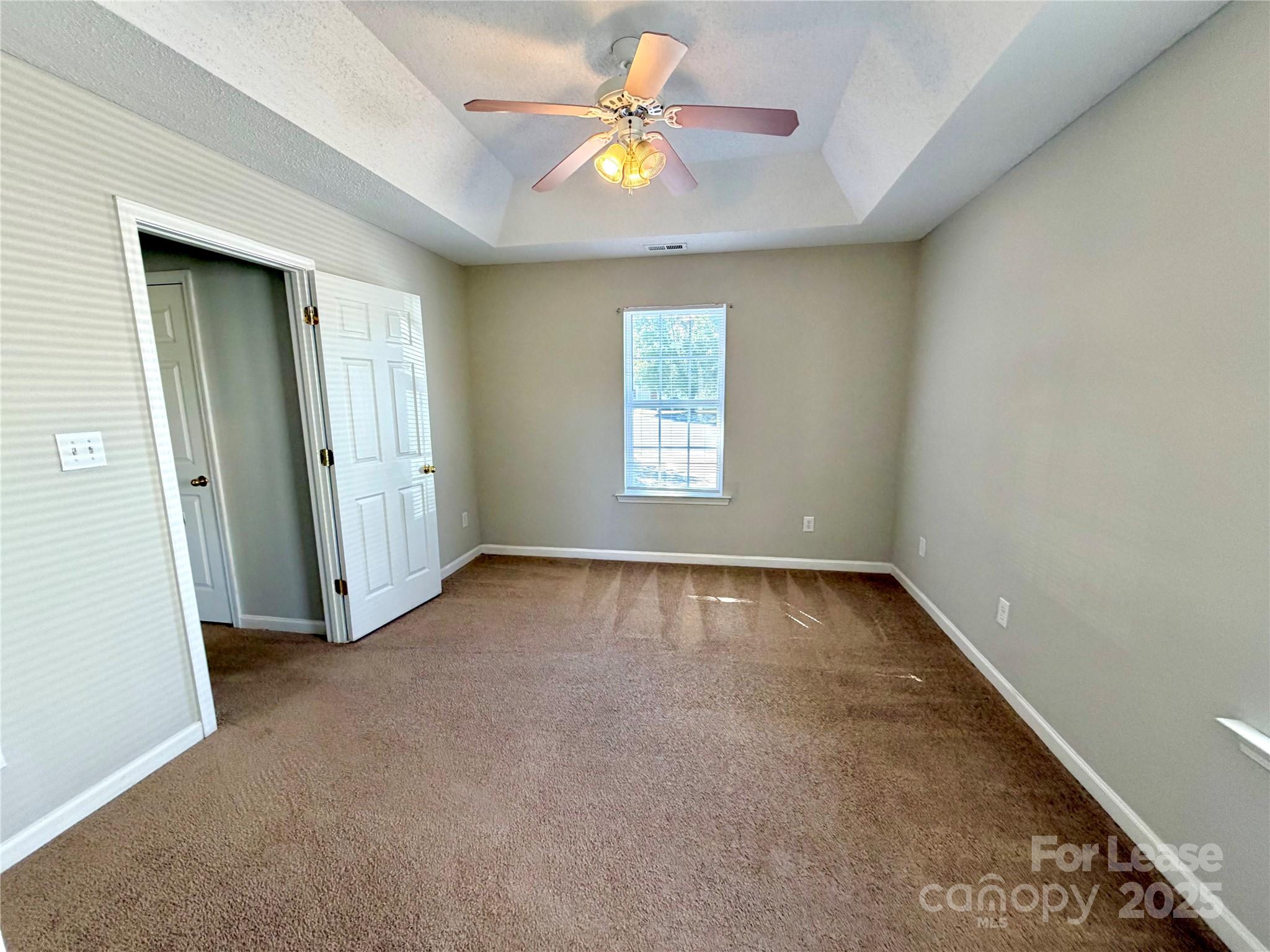 910 Rucker Cliff Drive Charlotte, NC 28214 - Photo 13 of 23 an empty room with windows and chandelier fan