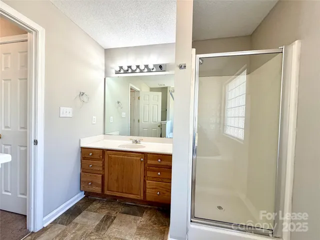 a bathroom with a granite countertop sink shower and a mirror