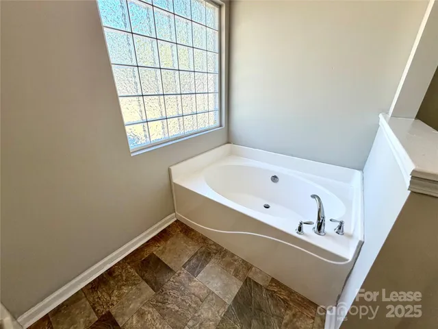 a bathroom with a bathtub and window