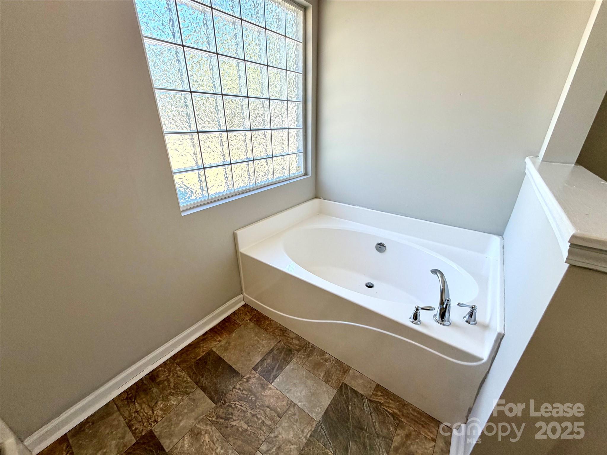 910 Rucker Cliff Drive Charlotte, NC 28214 - Photo 15 of 23 a bathroom with a bathtub and window