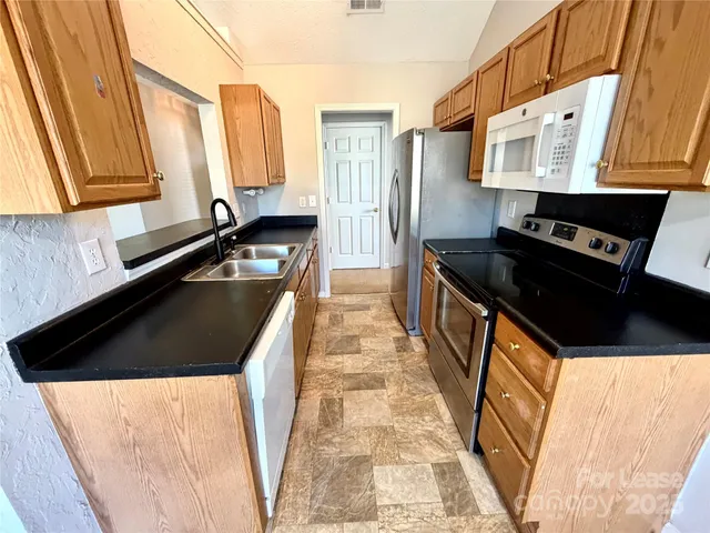 a kitchen with granite countertop a sink and a stove