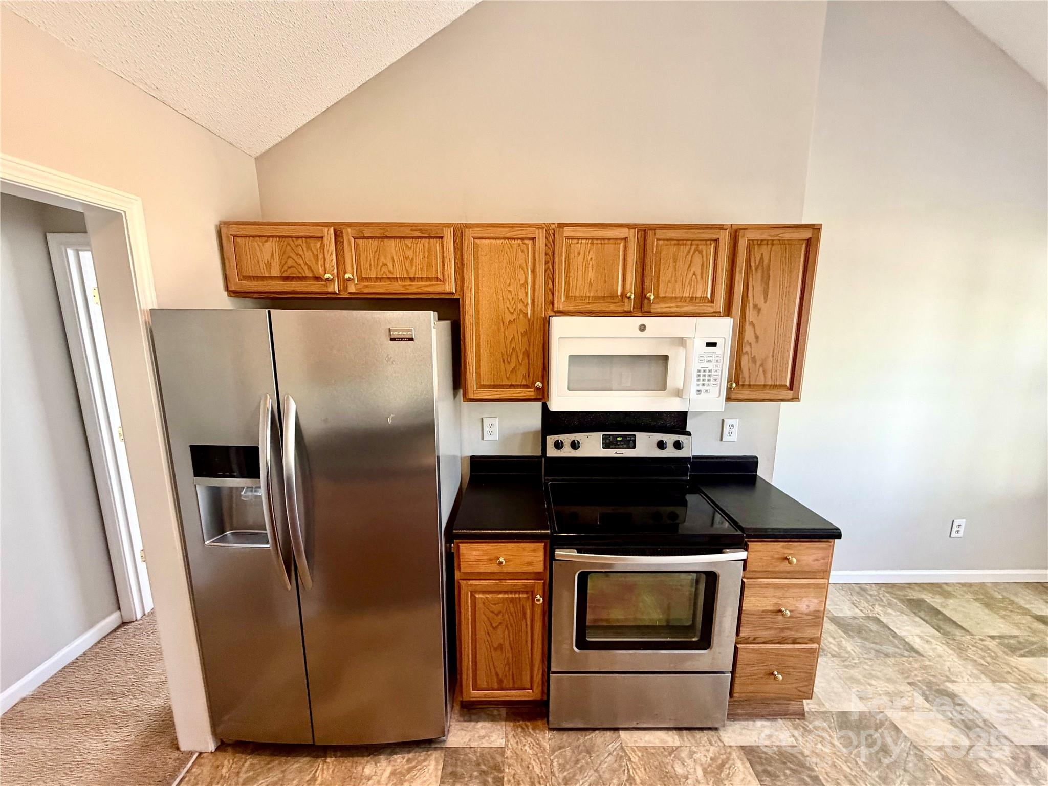 910 Rucker Cliff Drive Charlotte, NC 28214 - Photo 8 of 23 a kitchen with granite countertop a refrigerator and a stove top oven
