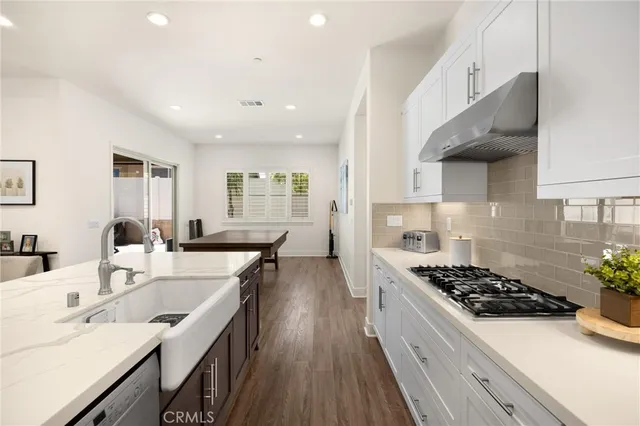 a living room with stainless steel appliances kitchen island granite countertop furniture wooden floor and view kitchen