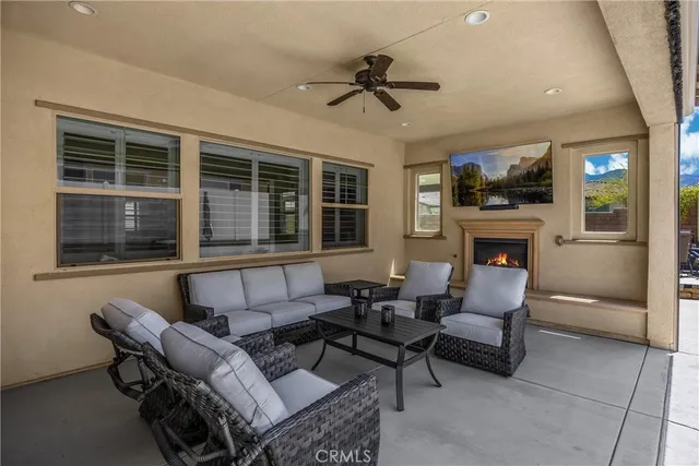 a view of a patio with couches table and chairs under an umbrella