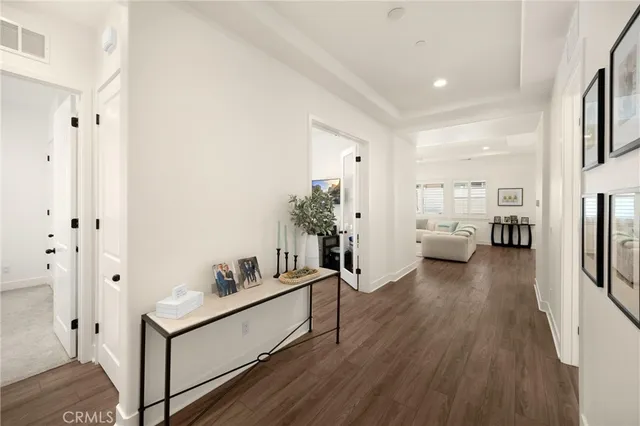 a kitchen with stainless steel appliances a table chairs in it and wooden floor