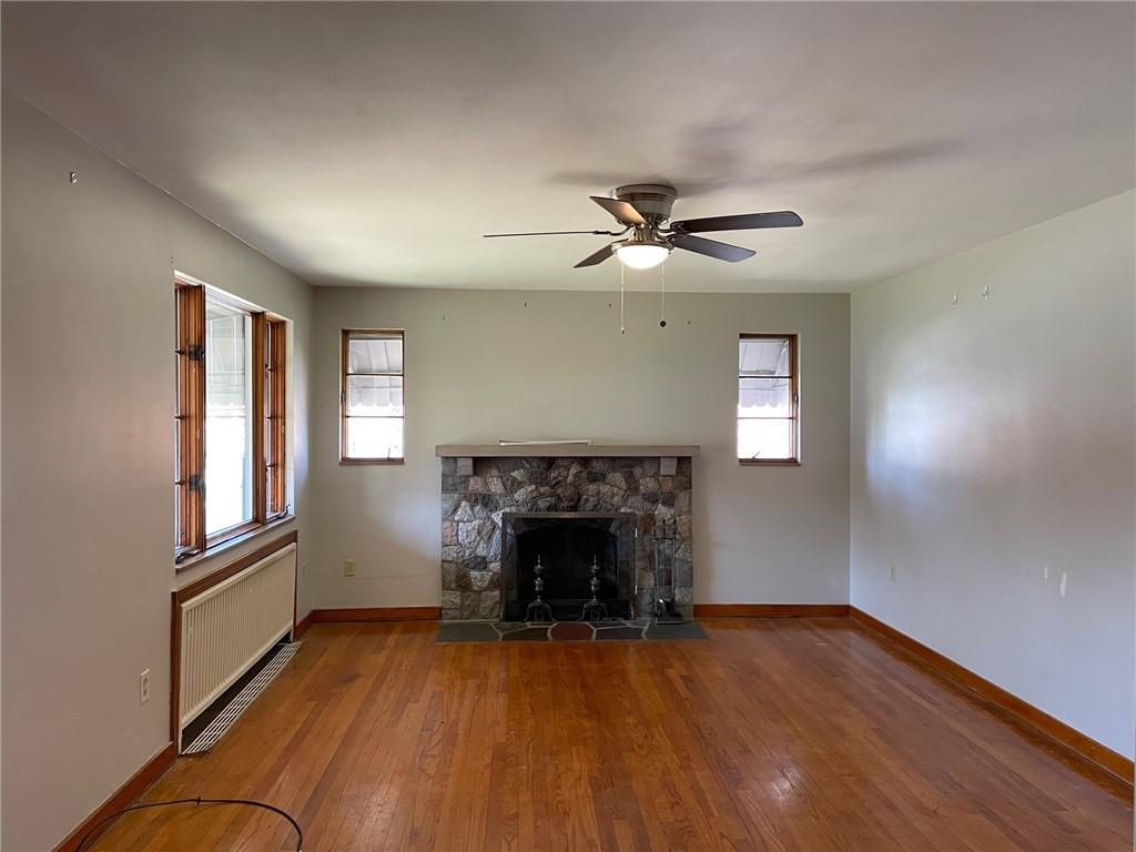 4517 Lincoln Avenue Jeannette, PA 15644 - Photo 11 of 37 an empty room with windows fireplace and wooden floor