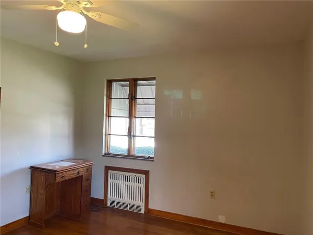 an empty room with wooden floor and closet area
