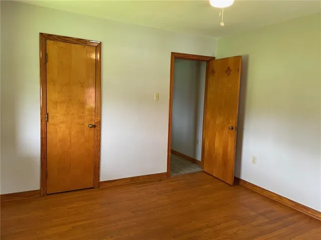 an empty room with wooden floor and a window