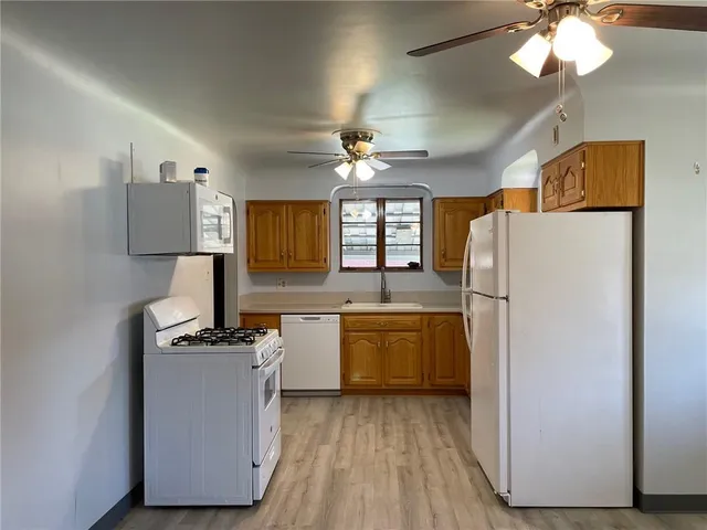 a kitchen with refrigerator cabinets and wooden floor