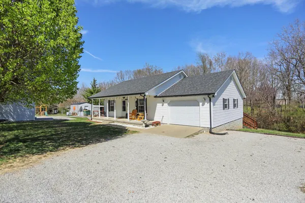 a view of house with outdoor space and trees in the background