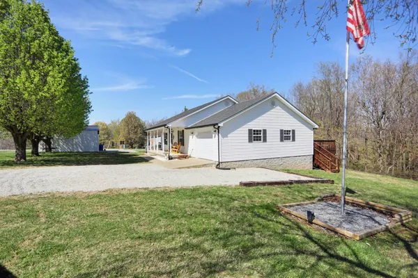 a view of house with backyard and trees