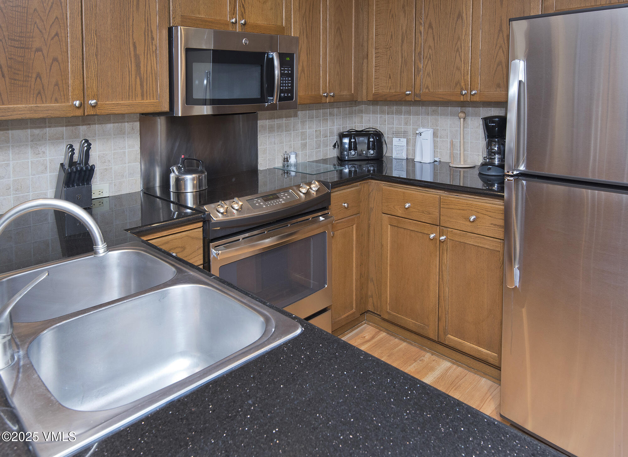 210 Offerson Road Beaver Creek, CO 81620 - Photo 21 of 30 a kitchen with stainless steel appliances granite countertop a refrigerator sink and microwave