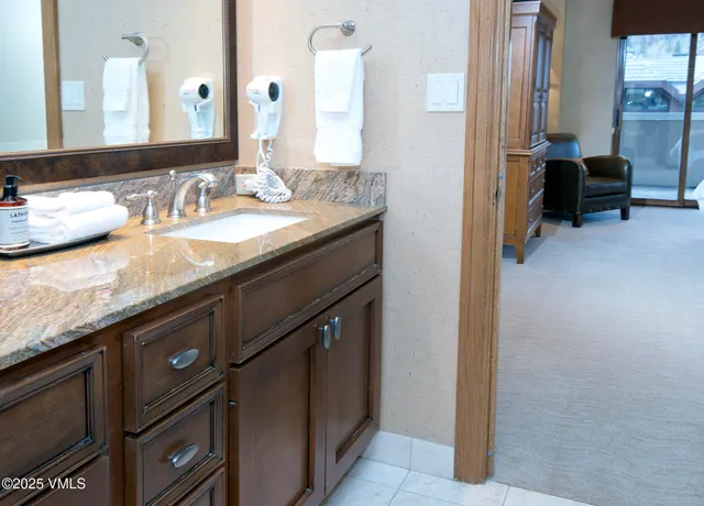 a bathroom with a granite countertop bathtub sink and mirror